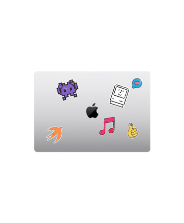 Lukket sølvfarvet MacBook Air vist ovenfra med klistermærker i forskellige farver omkring Apple-logoet