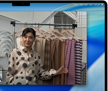 مكالمة فيديو على MacBook Pro تظهر فيها امرأة تعرض أقمشة لشخصين في المكالمة، بينما يحافظ نمط 'في الوسط' على بقائها في وسط الإطار أثناء تحركها