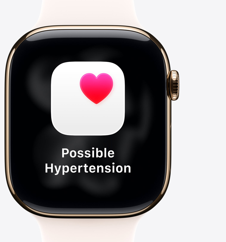 Apple Watch Series 11, titanium case, polished gold color, possible hypertension notification, pink heart in white box, right side exterior, Digital Crown, light blush Sport Band