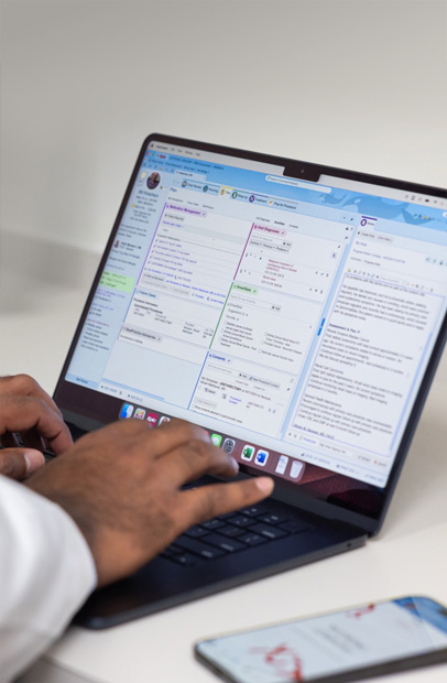 Un médecin consultant des dossiers médicaux numériques sur un MacBook Pro.