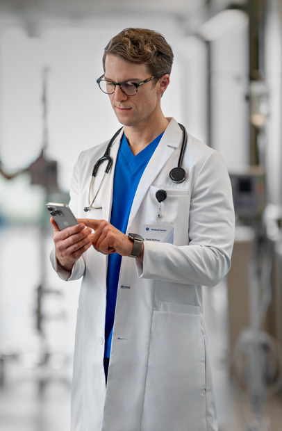 Un médecin consultant son iPhone pour vérifier des résultats médicaux dans un hôpital.
