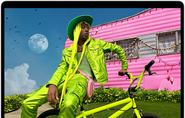 Liquid Retina ekranın renk aralığını ve çözünürlüğünü göstermek için MacBook Air ekranında renkli kıyafetli birinin fotoğrafı gösteriliyor